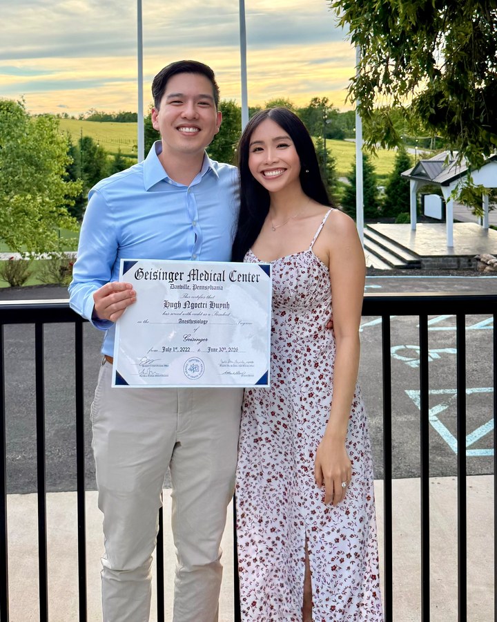 Christina with her fiancé Hugh, holding his anesthesiology residency certificate
