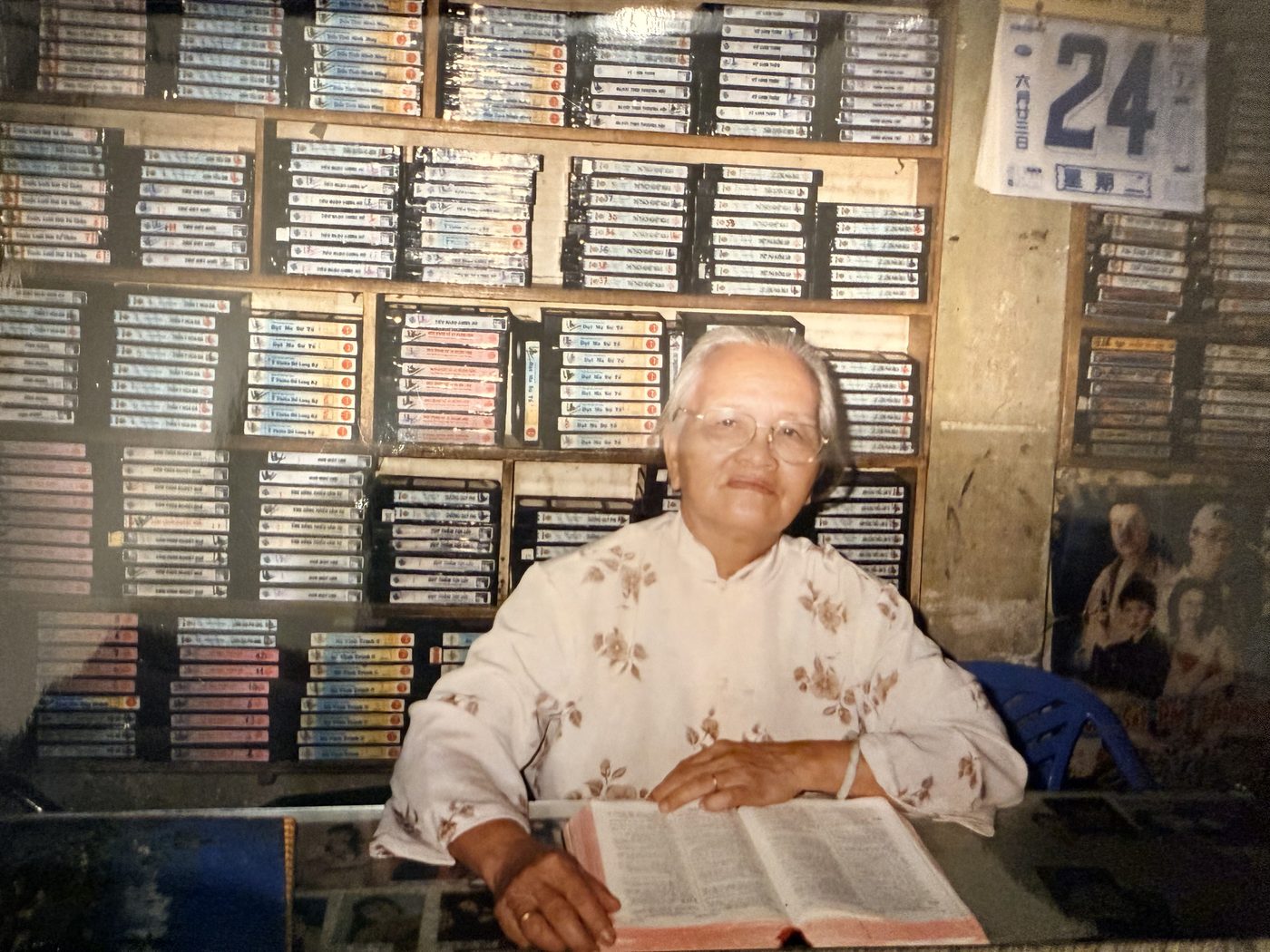 Christina's grandmother reading her Bible at Christina's parents' video rental shop in Vietnam
